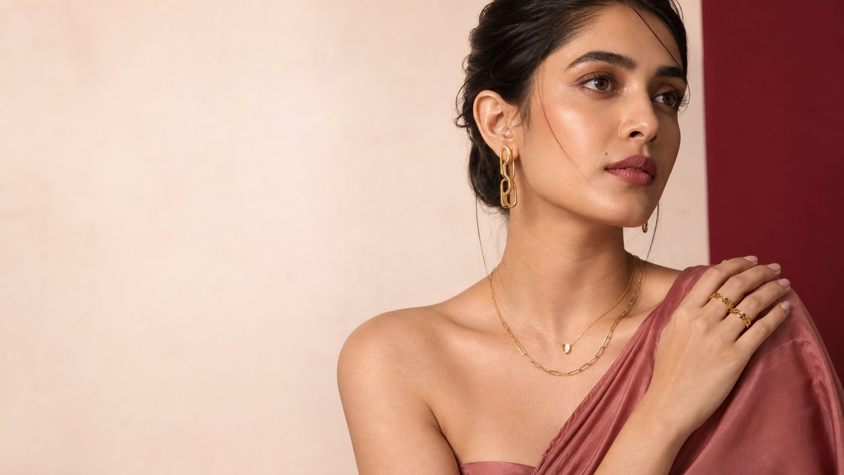 Woman styling contemporary gold jewellery